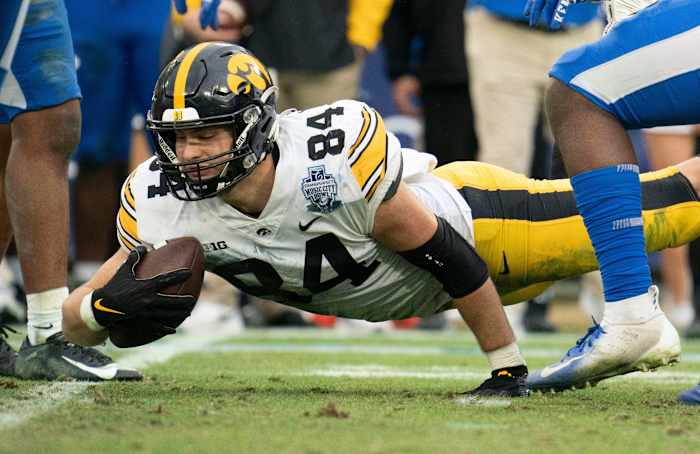 Iowa tight end Sam LaPorta (84) dives for extra yards past Kentucky defenders during the third quarter of the TransPerfect Music City Bowl at Nissan Stadium Saturday,